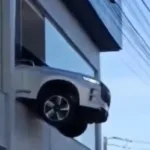 carro-fica-pendurado-no-1o-andar-de-loja-apos-manobra-de-funcionario.-veja-video