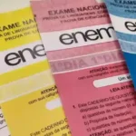 Candidato com tremores nas mãos usando computador no Enem