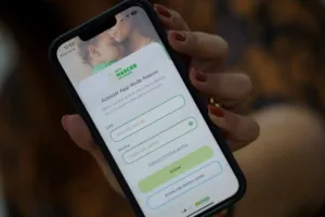 Mulher grávida utilizando aplicativo para gestantes no celular para acompanhar o pré-natal