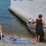 Mulher invade área masculina em praia separada por muro