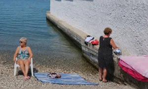 Mulher invade área masculina em praia separada por muro