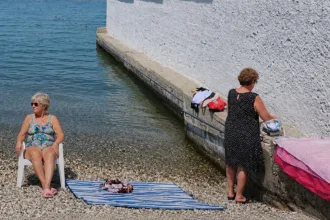 Mulher invade área masculina em praia separada por muro