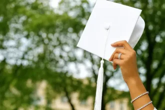 Estudante usando beca branca em respeito ao Candomblé