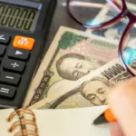 Dinheiro japonês e calculadora simbolizando crédito tributário reembolsável