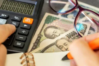 Dinheiro japonês e calculadora simbolizando crédito tributário reembolsável