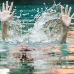 Criança segura em piscina, prevenindo afogamento infantil