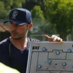 Treinador de futebol orientando jogadores em campo