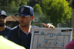 Treinador de futebol orientando jogadores em campo