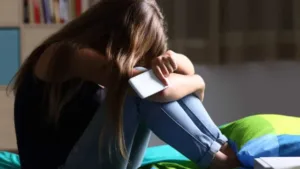 Adolescente em frente ao computador, preocupado com coerção online