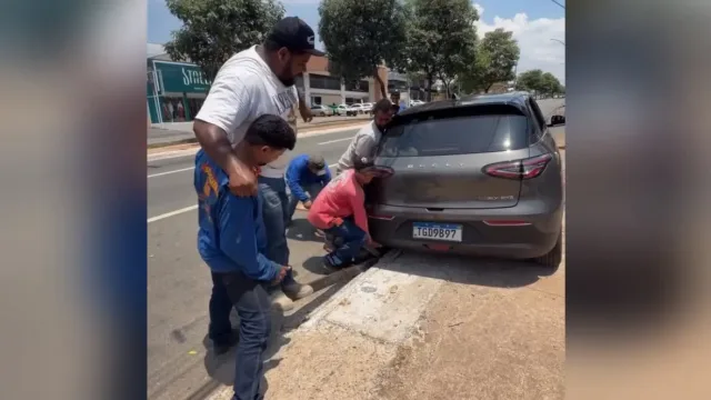 Carro de empresária fica preso em bueiro e 12 homens se unem para levantar veículo em Goiânia: ‘sem querer’